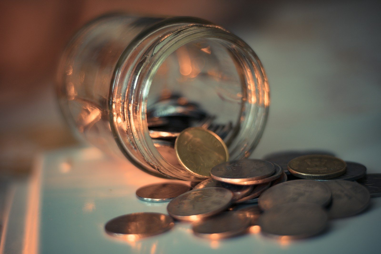 Frasco de cristal transparente lleno de monedas de ahorro